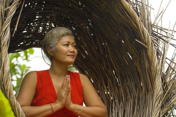 Atraente e feliz 40 ou 50 anos de idade média mulher asiática em elegante e bonito vestido vermelho praticando ioga relaxamento e meditação na selva tropical — Fotografia de Stock