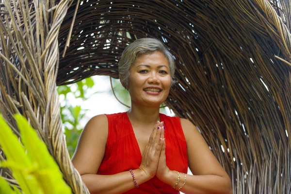 Atraente e feliz 40 ou 50 anos de idade média mulher asiática em elegante e bonito vestido vermelho praticando ioga relaxamento e meditação na selva tropical — Fotografia de Stock