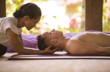 egzotik Asya Bali terapist kadın uyum sağlık ve sağlıklı yaşam tarzı içinde Kafkas adama geleneksel baş ve yüz Tay masajı veren rahatlatıcı tropikal spa