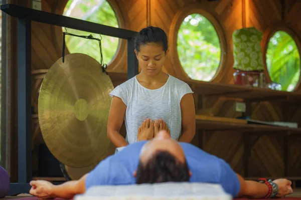 Jovem bonito e exótico asiático balinês wellness terapeuta dando corpo massagem tailandesa para atraente homem caucasiano no tradicional jardim spa em cuidados de saúde conceito de relaxamento — Fotografia de Stock