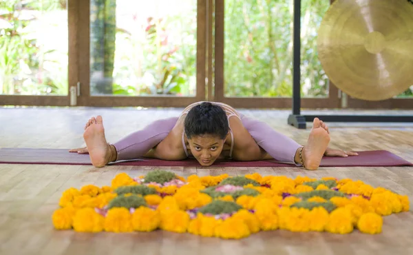 Joven atractiva y saludable Asiática indonesia acróbata mujer practicando acro yoga ejercicio en equilibrio pose en estudio tradicional entrenamiento concentrado en armonía — Foto de Stock