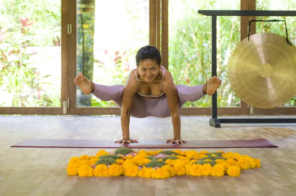Joven atractiva y saludable Asiática indonesia acróbata mujer practicando acro yoga ejercicio en equilibrio pose en estudio tradicional entrenamiento concentrado en armonía — Foto de Stock
