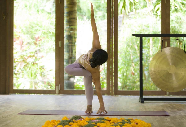 Joven atractiva y saludable Asiática indonesia acróbata mujer practicando acro yoga ejercicio en equilibrio pose en estudio tradicional entrenamiento concentrado en armonía — Foto de Stock