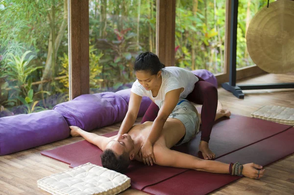 Joven hermosa y exótica mujer terapeuta indonesia asiática dando masaje tailandés tradicional al hombre relajado en el spa tropical de bienestar en estilo de vida natural saludable —  Fotos de Stock