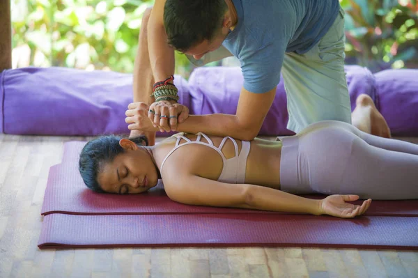 Junge schöne und exotische asiatische Balinesin, die auf einer Matte liegt und traditionelle thailändische Massage durch einen Masseur im tropischen Wellness-Kurpark im Gesundheitskonzept erhält — Stockfoto