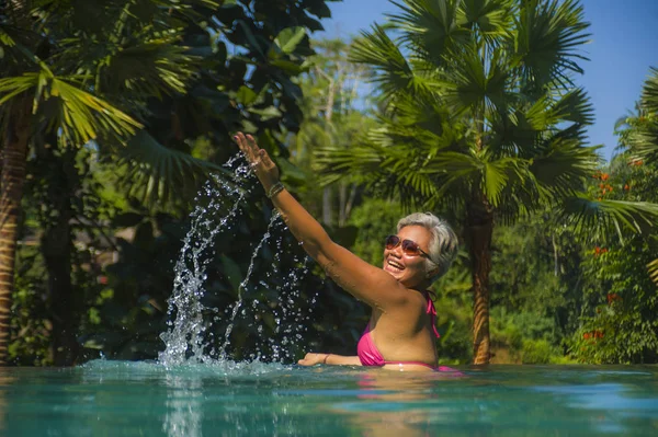 매력적이고 행복한 중년 아시아 여성은 럭셔리 휴가 여행에서 휴식을 즐기는 정글 배경열대 리조트 인피니티 수영장에서 휴식을 취했습니다. — 스톡 사진