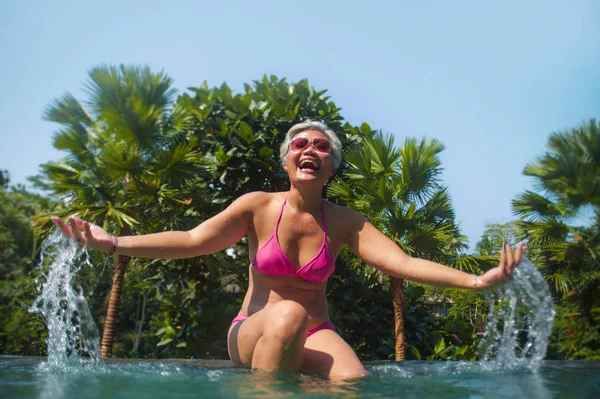 Attraktive und glückliche asiatische Frau mittleren Alters entspannt im tropischen Resort Infinity-Pool mit Dschungel-Hintergrund genießen entspannt in Luxus-Urlaub Reise — Stockfoto