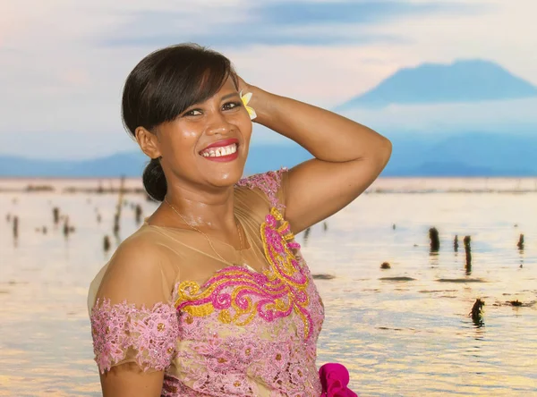 Belle femme balinaise indonésienne d'âge moyen heureux en robe de cérémonie traditionnelle à la plage tropicale avec fond volcanique Bali Agung dans la destination touristique de vacances — Photo