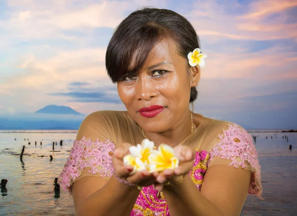 Красиві щасливі середнього віку Індонезійська балійскій жінка в традиційному одязі церемонія в тропічному пляжі з Балі Agung вулкана тлі у відпустку туристичний напрямок — стокове фото