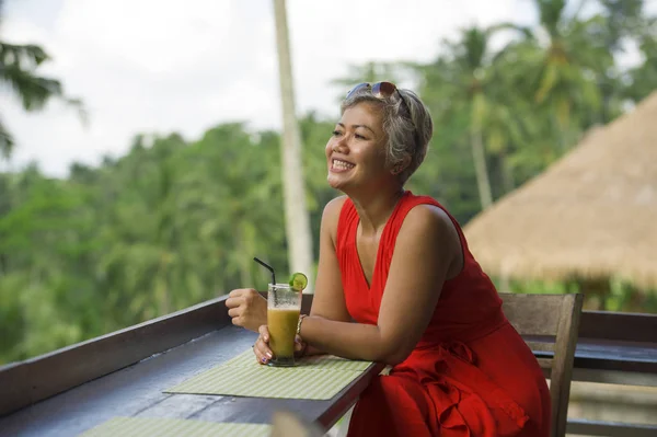 Estilo de vida natural ao ar livre retrato da mulher indonésia asiática de meia idade atraente e feliz em vestido vermelho elegante desfrutando de viagem de férias tropicais no resort turístico — Fotografia de Stock