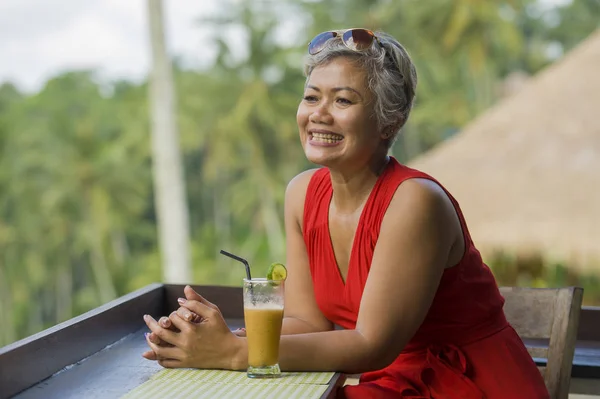 Estilo de vida natural al aire libre retrato de mujer indonesia asiática atractiva y feliz de mediana edad en vestido rojo con estilo disfrutando de viaje de vacaciones tropicales en el complejo turístico —  Fotos de Stock