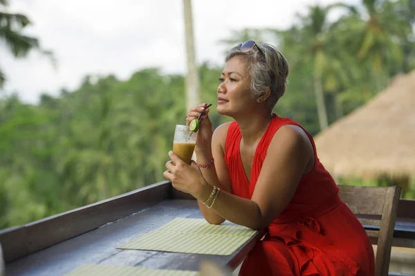 Estilo de vida natural ao ar livre retrato da mulher indonésia asiática de meia idade atraente e feliz em vestido vermelho elegante desfrutando de viagem de férias tropicais no resort turístico — Fotografia de Stock