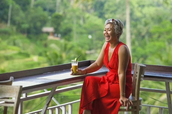 Estilo de vida natural al aire libre retrato de mujer indonesia asiática atractiva y feliz de mediana edad en vestido rojo con estilo disfrutando de viaje de vacaciones tropicales en el complejo turístico — Foto de Stock