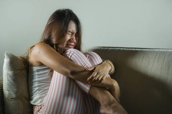 Giovane triste e depresso asiatico indonesiano donna seduta a casa divano piangendo frustrato e sconvolto sofferenza stress e depressione dopo rottura — Foto Stock