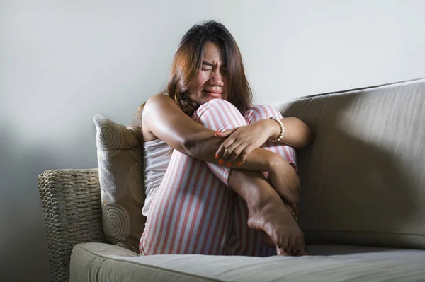 Jovem triste e deprimido asiático indonésio mulher sentado em casa sofá chorando frustrado e chateado sofrendo estresse e depressão após o rompimento — Fotografia de Stock