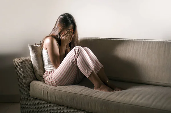 Joven mujer triste y deprimida en pijama en el sofá de casa llorando desesperado sintiéndose frustrado y molesto sufriendo estrés y depresión después de la ruptura — Foto de Stock