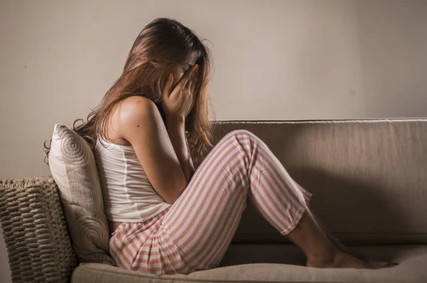 Ung ledsen och deprimerad kvinna i pyjamas hemma soffa gråter desperat känsla frustrerad och upprörd lidande stress och depression efter uppbrott — Stockfoto