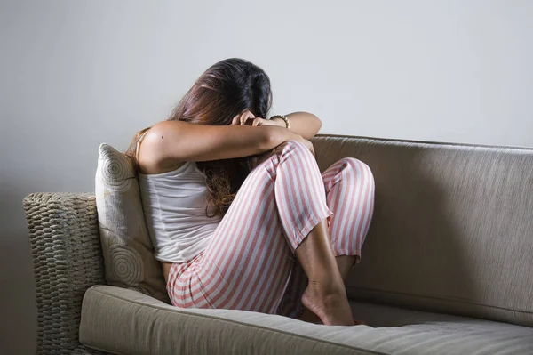 Joven mujer triste y deprimida en pijama en el sofá de casa llorando desesperado sintiéndose frustrado y molesto sufriendo estrés y depresión después de la ruptura — Foto de Stock