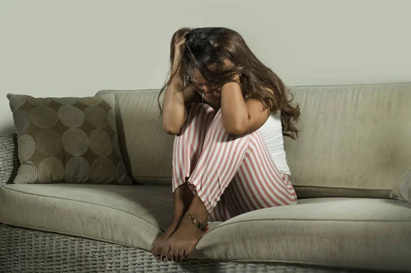 Nuori surullinen ja masentunut nainen pyjamassa kotona sohvalla itkien epätoivoinen tunne turhautunut ja järkyttynyt kärsimystä stressiä ja masennusta hajoamisen jälkeen — kuvapankkivalokuva
