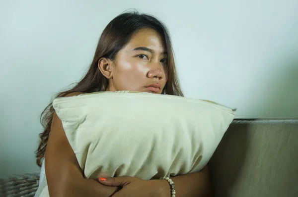 Genç üzgün ve bunalımlı Endonezyalı kadın. Kanepesinde ağlayan, hayal kırıklığına uğramış ve üzüntülü bir şekilde ayrılık sonrası depresyona girmiş. — Stok fotoğraf