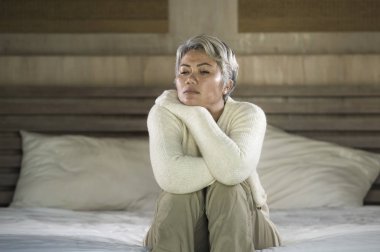 depresif ve üzgün gri saç olgun kadın yalnız acı ve depresyon sorunu duygu kriz içinde yatakta oturan ağlayan kayıp ve evde bunalmış duygu
