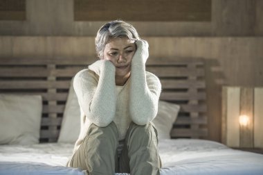 yatakta gri saçlı çekici üzgün ve depresif orta yaşlı kadının dramatik yaşam tarzı ev portresi depresyon ve anksiyete acı üzgün duygu
