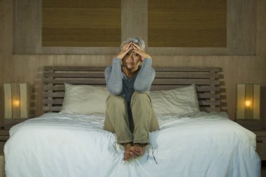  yatakta gri saçlı çekici üzgün ve depresif orta yaşlı kadının dramatik yaşam tarzı ev portresi depresyon ve anksiyete acı üzgün duygu
