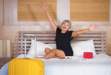 tatil otel odasında tatil otel odasında gelen gri saçlı mutlu ve çekici olgun Asyalı turist kadının portresi tatil gezisi başlayan eğlenceli yatak heyecanlı