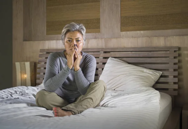Depressed and sad grey hair mature woman crying lonely sitting on bed suffering crisis in pain and depression problem feeling lost and overwhelmed at home — Stock Photo, Image