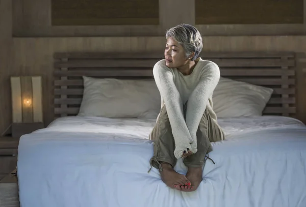 Депрессивные и грустные седые волосы зрелая женщина плачет одиноко сидя на кровати страдает кризисом боли и депрессии проблема чувствует себя потерянным и подавлен дома — стоковое фото
