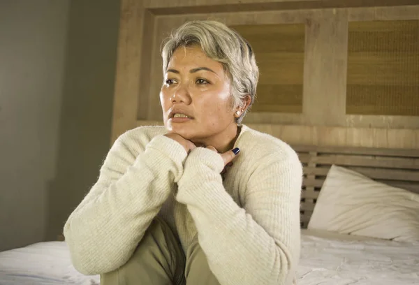 Mode de vie dramatique portrait à la maison d'attrayant triste et déprimé femme d'âge moyen avec les cheveux gris sur le lit sentiment bouleversé souffrant de dépression et d'anxiété — Photo