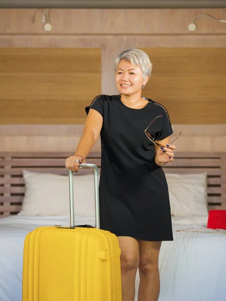 Портрет счастливой и привлекательной 40-50-летней зрелой азиатки с седыми волосами, прибывающей в гостиничный номер взволнованной улыбающейся веселой наслаждающейся отпуском поездкой — стоковое фото