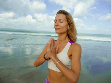 Güzel plajda yoga egzersizi. Genç, mutlu ve çekici sağlıklı bir kadın. Yoga ve rahatlama egzersizleri yapıyor.