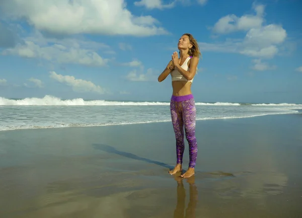 Porträt einer jungen glücklichen und attraktiven, schlanken blonden Frau, die Yoga und Entspannungsübungen am schönen Strand in Entspannung und Meditation macht — Stockfoto