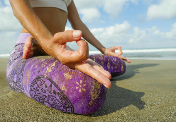 hands and fingers posture detail of woman sitting in lotus position doing yoga and relaxation exercise outdoors at beautiful beach in relax and meditation practice