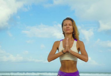 yoga güzel plajda çekici ve mutlu atletik kız sağlıklı yaşam tarzı ve sağlıklı yaşam içinde meditasyon egzersiz açık havada yapıyor konsantre ve rahat poz 