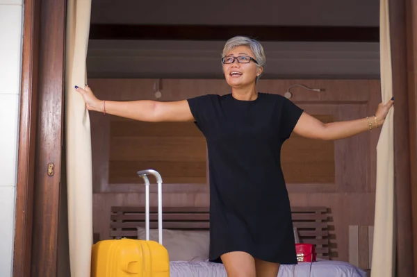 Atractiva y feliz de mediana edad mujer asiática con estilo vestido de verano que llega a la puerta del balcón habitación de apertura del hotel buscando encantado disfrutando de vacaciones de viaje escapada — Foto de Stock