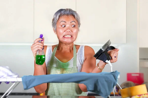 Stressé moyen âge asiatique femme repassage dans le stress à la maison cuisine sentiment accablé et fatigué de travailler tâches domestiques dans le ménage sans défense femme — Photo