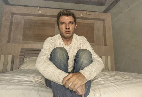 Dramático retrato en casa de 30 a 40 años atractivo hombre deprimido y desesperado sentado en la cama sufriendo crisis de ansiedad y depresión problema llorando triste y reflexivo — Foto de Stock