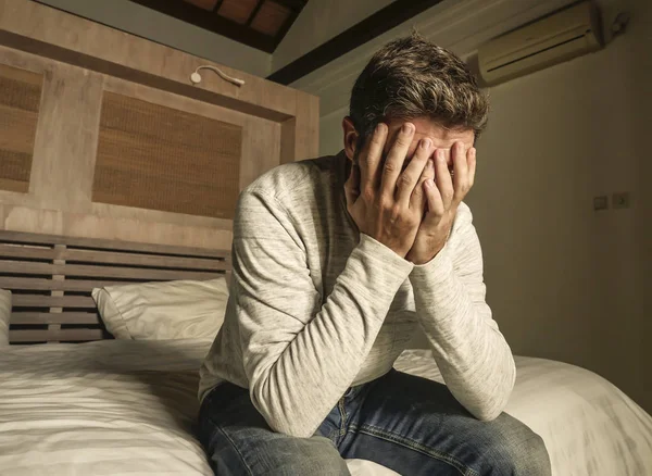 Dramatic home portrait of 30s to 40s depressed and desperate man in pain sitting on bed suffering anxiety crisis and depression problem crying sad and frustrated — Stock Photo, Image