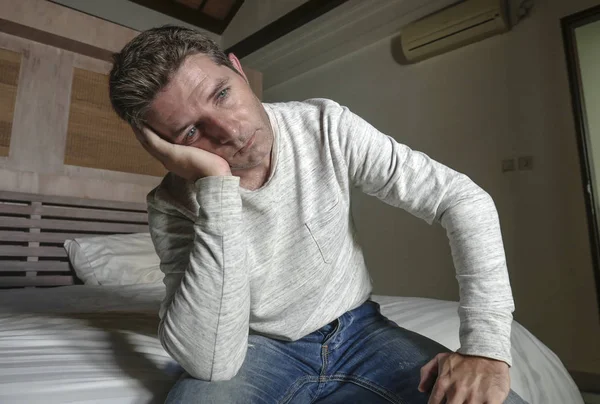 Dramático home retrato de 30 a 40 anos atraente deprimido e desesperado homem sentado na cama sofrendo crise de ansiedade e depressão problema chorando triste e pensativo — Fotografia de Stock