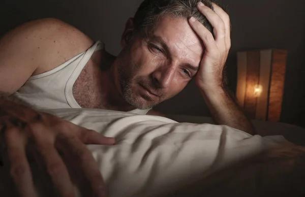 Verzweifelter und depressiver Mann mittleren Alters, der nicht schlafen kann, leidet unter Angstkrise und Depressionen und fühlt sich im Bett überfordert und frustriert — Stockfoto