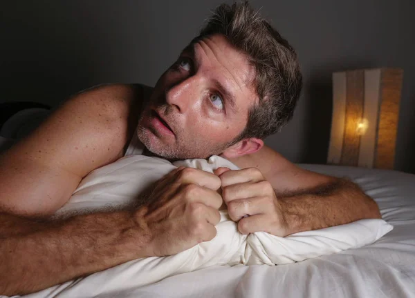 Portret stylu życia młodych atrakcyjne przerażony i paranoidalny człowiek leżącego w łóżku o złe sny i koszmary rozglądając się w zabawny wyraz twarzy cierpienie paranoja — Zdjęcie stockowe