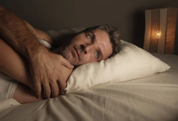 Potret wajah laki-laki yang menarik sedih dan bijaksana berbaring di tempat tidur terjaga larut malam memikirkan perasaan khawatir dan prihatin setelah perceraian — Stok Foto