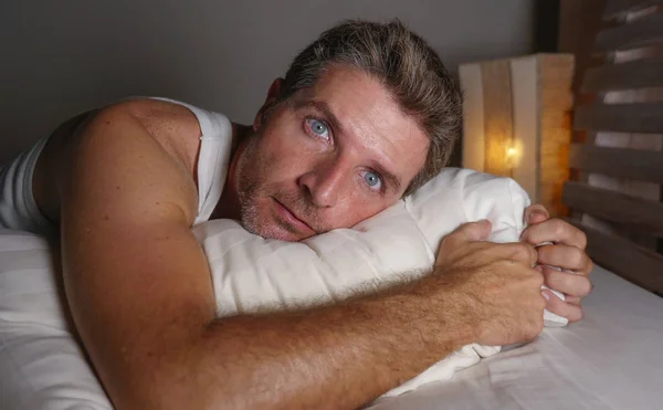 Portrait rapproché du visage d'un homme séduisant insomniaque et éveillé, les yeux grands ouverts la nuit, allongé sur son lit souffrant d'insomnie, essayant de dormir — Photo