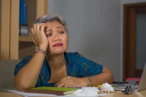 Office спосіб життя портрет сумної і депресії середнього віку привабливою азіатській жінці, що працює на ноутбуці портативний комп'ютер підкреслив і втомився почуття перевантажені — стокове фото