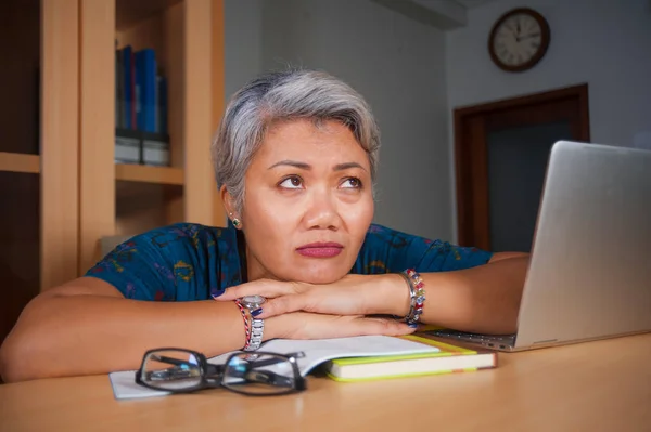 Escritório estilo de vida retrato de triste e deprimido meia-idade atraente mulher asiática trabalhando no laptop computador mesa estressado e cansado sentimento oprimido — Fotografia de Stock