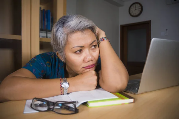 Office Lifestyle portret van verdrietig en depressief middelbare leeftijd aantrekkelijke Aziatische vrouw werken aan laptop computer bureau gestrest en moe gevoel overweldigd — Stockfoto