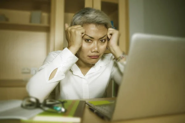 魅力的な落ち込みと悲しい成熟したアジアのビジネスウーマンは、ストレスと圧倒された不安の危機とうつ病を感じてオフィスのコンピュータデスクで働く — ストック写真
