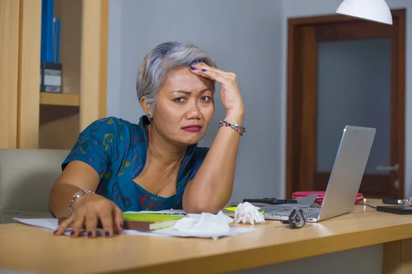Office Lifestyle portret van verdrietig en depressief middelbare leeftijd aantrekkelijke Aziatische vrouw werken aan laptop computer bureau gestrest en moe gevoel overweldigd — Stockfoto